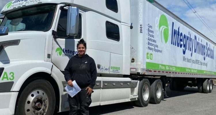 Integrity Driving School student beside a Class 1 MELT training tractor-trailer in British Columbia