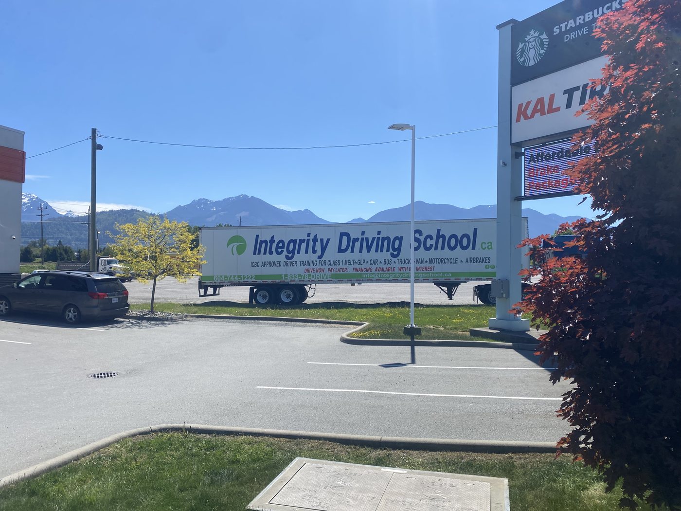 Integrity Driving School branded trailer parked in Chilliwack with the Fraser Valley mountains behind it