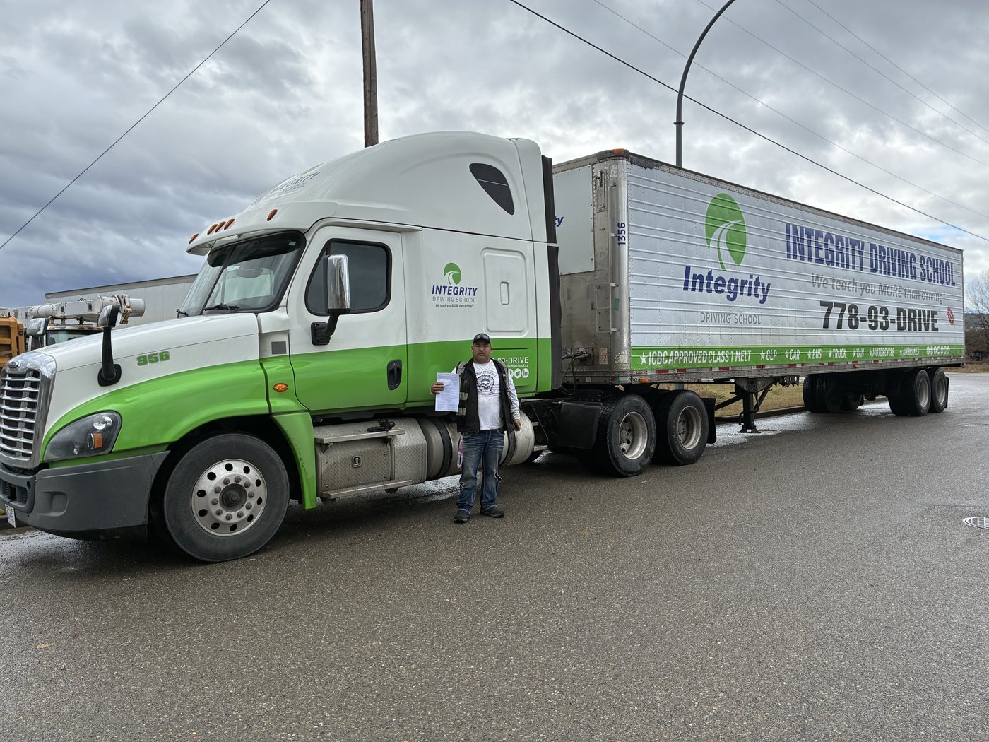 Integrity Driving School Class 1 graduate beside a branded tractor and trailer in Prince George